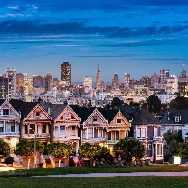 As famosas 画现在 da Alamo Square são retratadas diante do horizonte de 贝博体彩app ao crepúsculo.